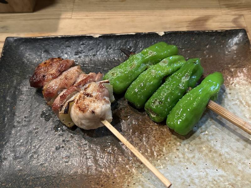 石の器にのった炭火焼きの鶏串とししとう串