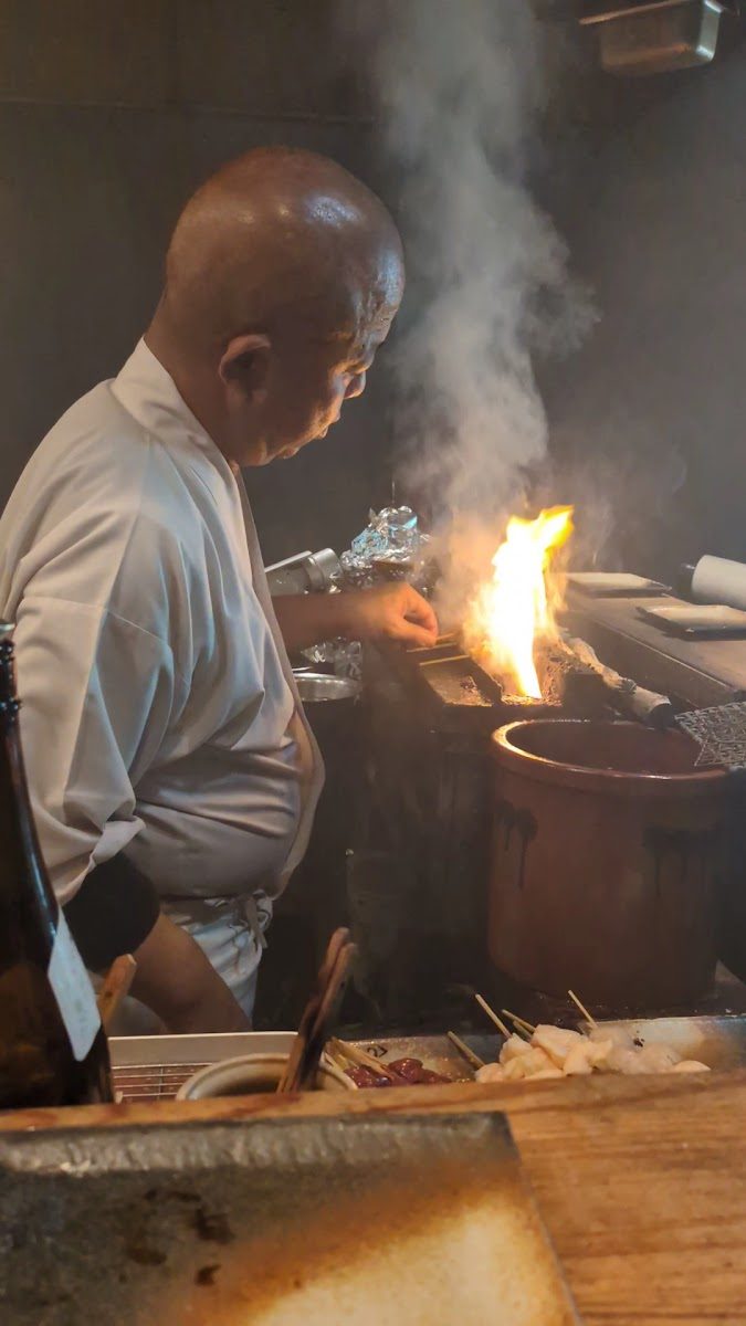 炭火で串を焼き上げる店主